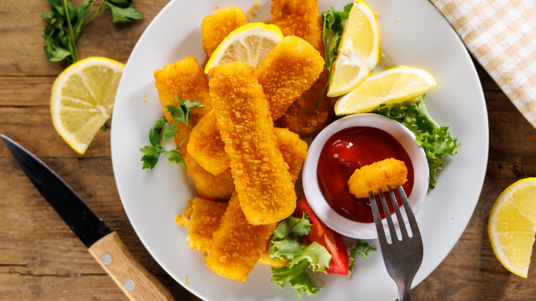 Fish sticks with ketchup and lemon slices