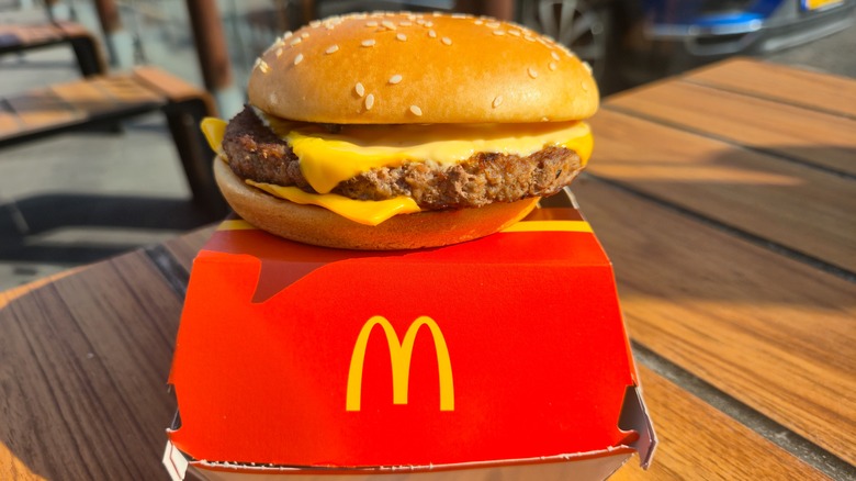 McDonald's cheeseburger atop box on restaurant table
