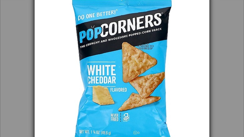 A light blue packet of PopCorners White Cheddar with a chunk of cheddar and chips on the package