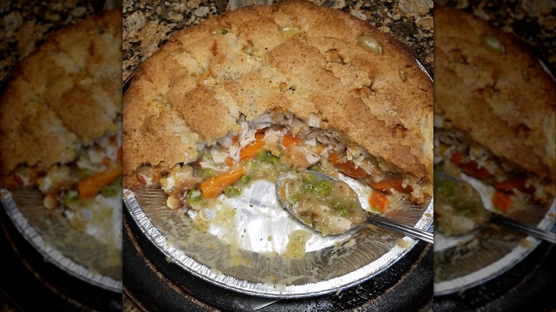 Half eaten Kirkland chicken pot pie in pie pan with a spoon