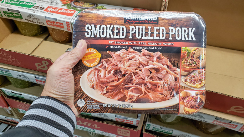 Hand holding package of Kirkland smoked pulled pork