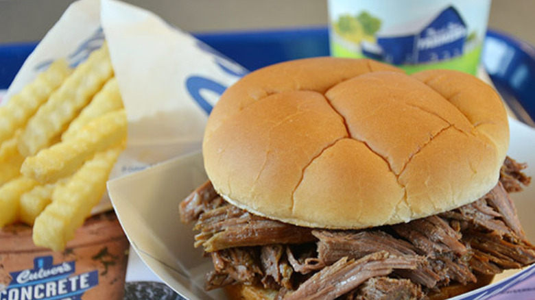 a pot roast sandwich with crinkle cut fries and a drink on a Culver's tray