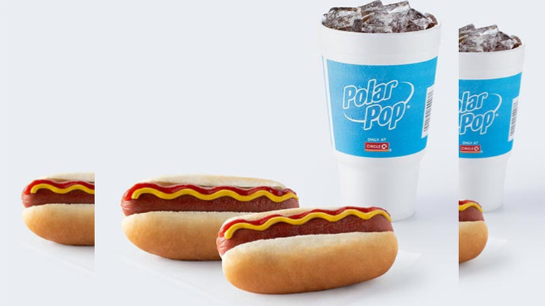 two hot dogs with ketchup and mustard and a large Polar Pop soda against a white background