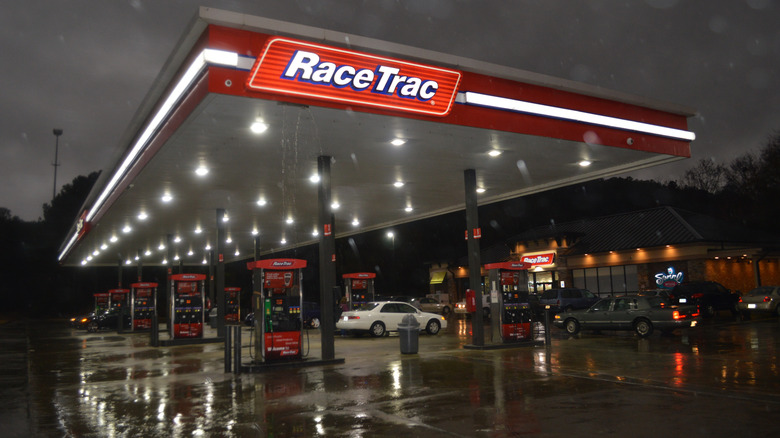 exterior view of a RaceTrac gas station at night, with lights turned on above the pumps