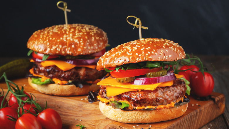 Cheeseburgers with lettuce, tomatoes, onions, pickles