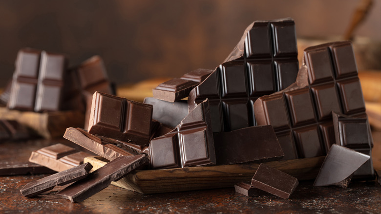 Broken chocolate bar shards on a brown countertop