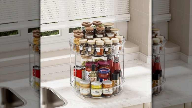 Two-tier lazy Susan holding spices and condiments on kitchen counter.