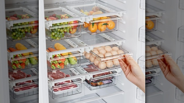 Hand pulling out under-shelf fridge drawer.