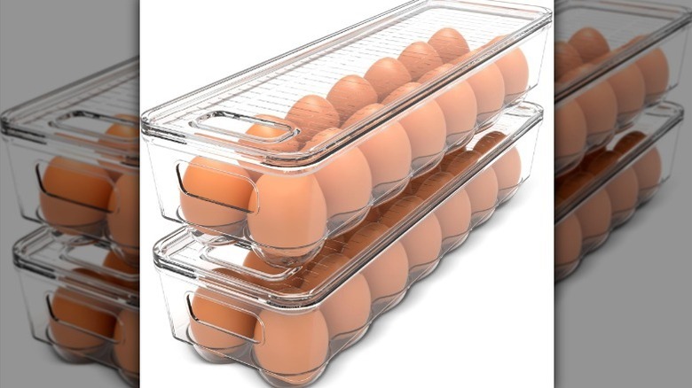 Clear egg containers with eggs on white background.