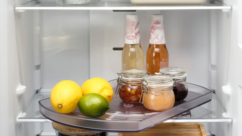 The Snurrad, an oval-shaped Lazy Susan, storing jams and fruits and drinks inside a refrigerator