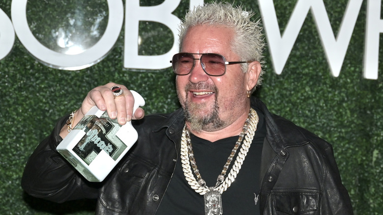Guy Fieri holding a bottle