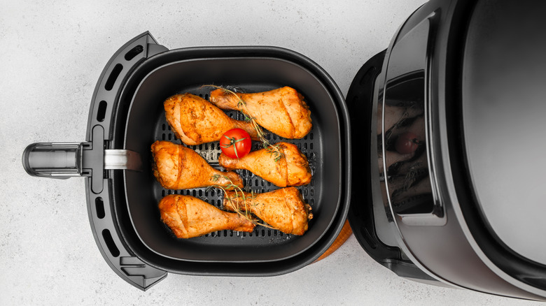 Roasted chicken drumsticks in an air fryer basket