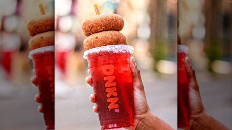 Red iced drink with two donuts stacked on top
