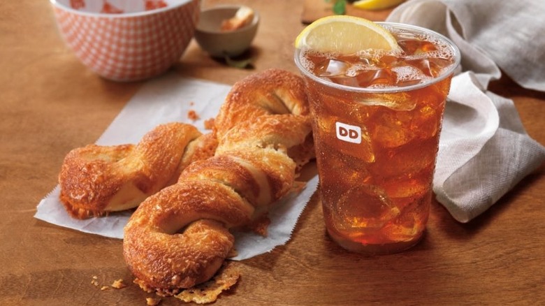 Flaky Dunkin' Bagel Twists on a napkin, with a plastic cup of iced tea