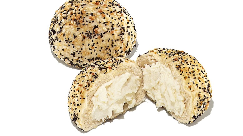 Small everything bagels with one cut open to show a cream cheese filling
