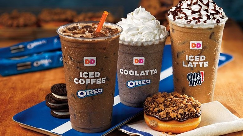 Cookie infused coffees in takeout cups, with a chocolate donut