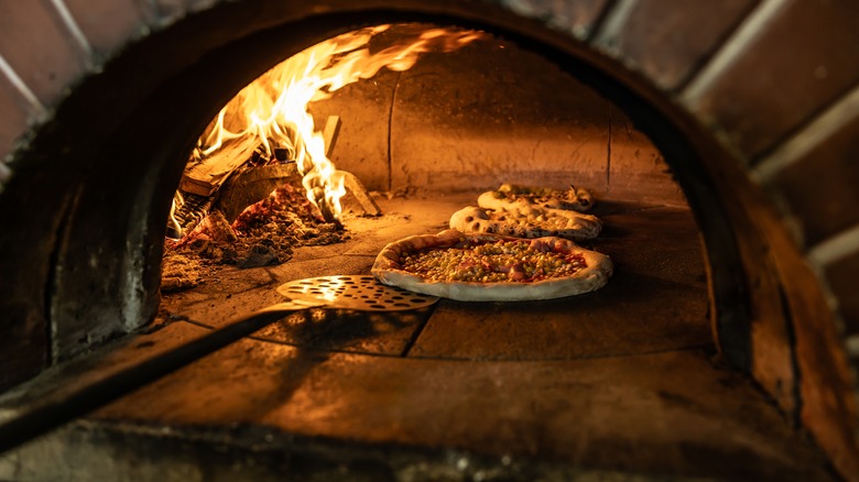 A pizza crisping up in a wood-fired oven