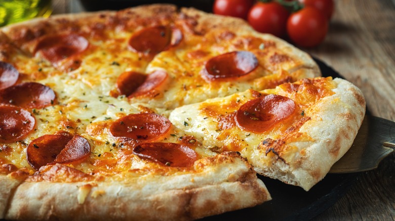 Homemade pizza with pepperoni on a pizza stone