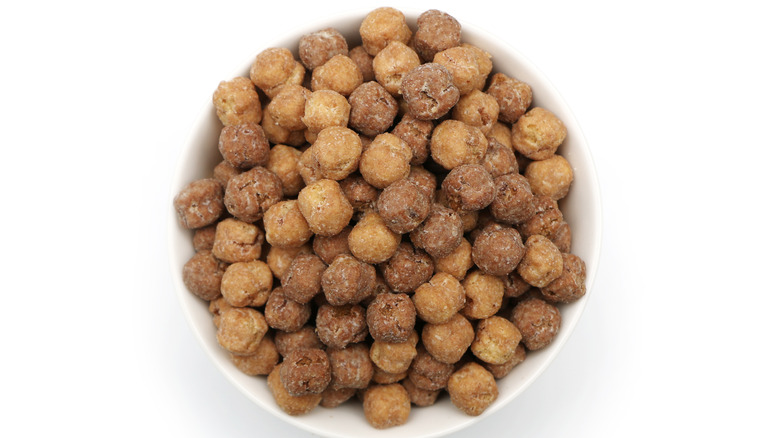 bowl filled with reese's puffs cereal on white background