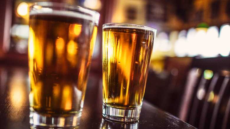 Two golden pints of beer on a bar