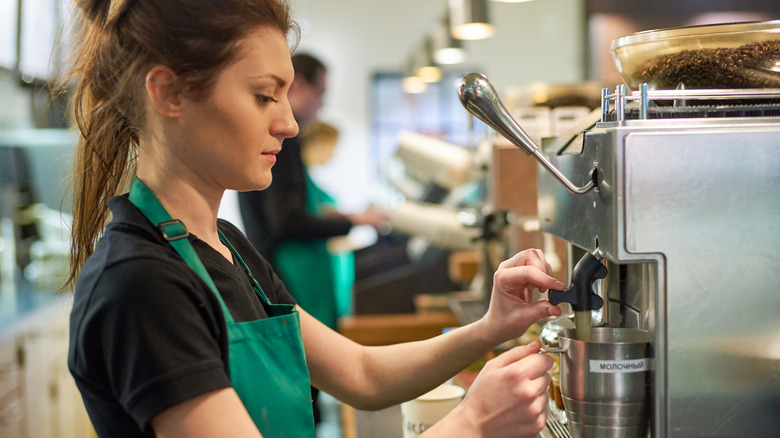 A Starbucks barista steams milk