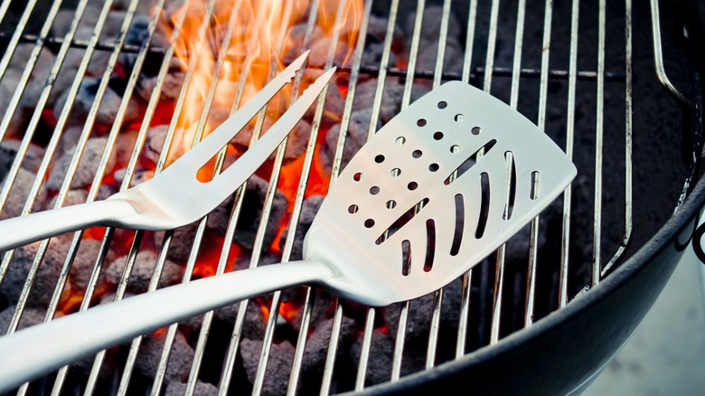 Slotted spatula and fork on a BBQ grill
