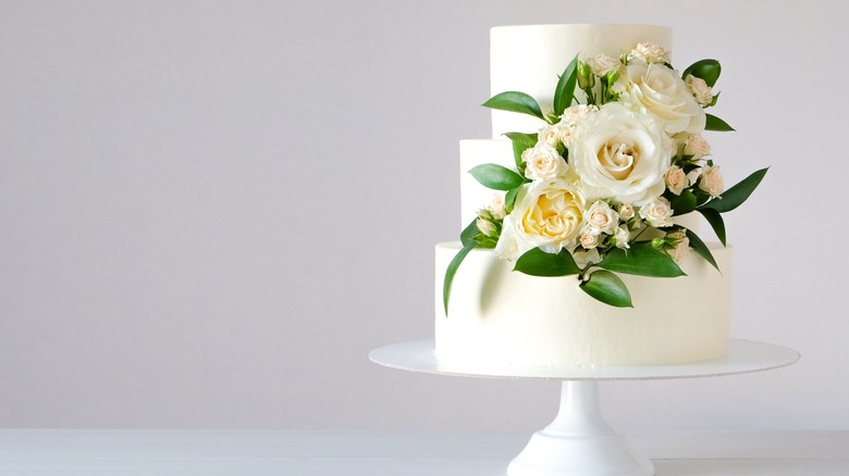 Wedding cake on stand with flowers