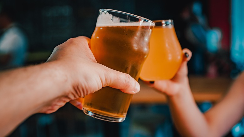 Two people cheer beers