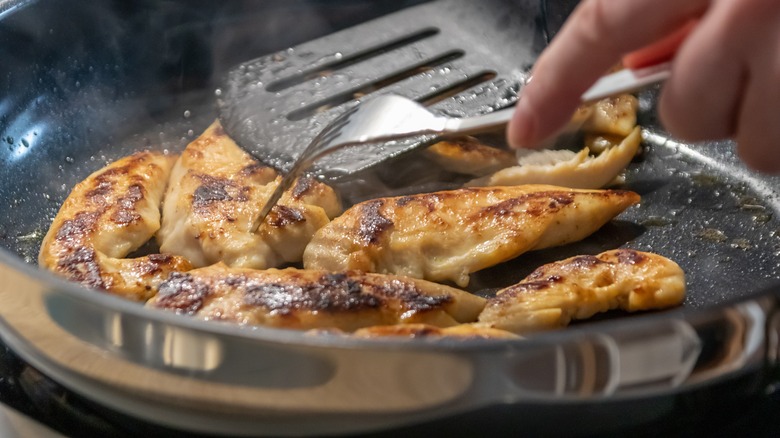 poking cooked chicken with a fork