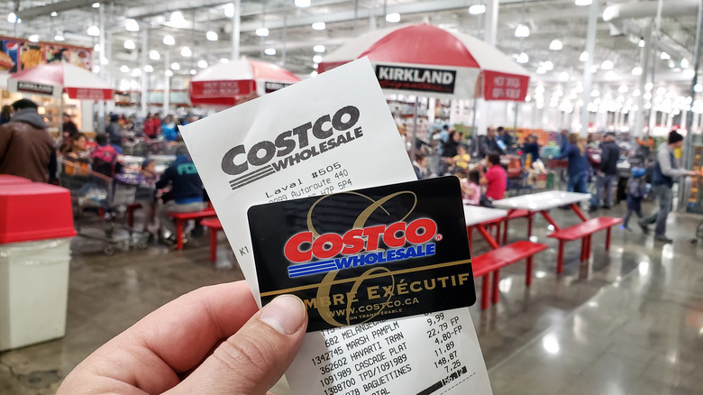 customer holding up Costco Executive member card and receipt