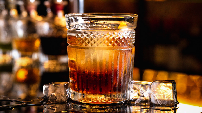 Old fashioned cocktail on bar next to ice