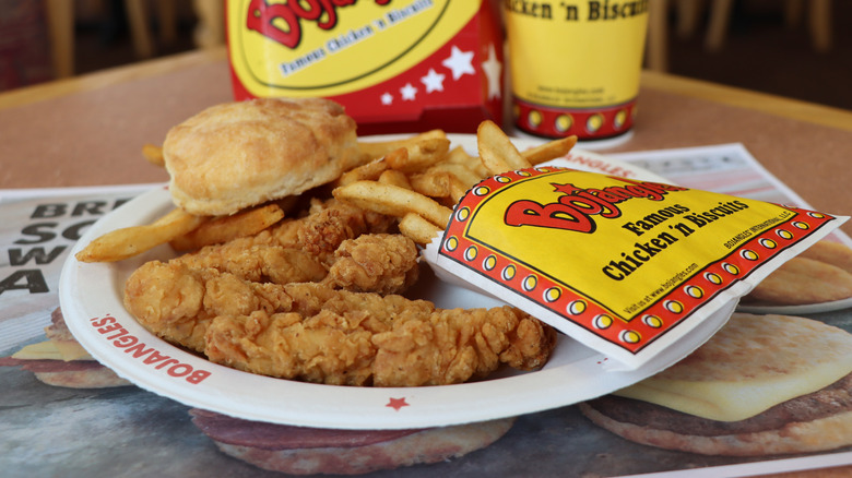 A plate of Bojangles chicken tenders, fries, and a biscuit
