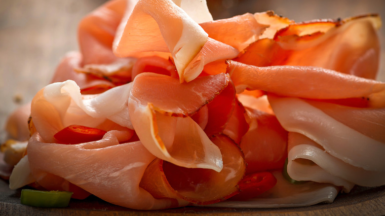 sliced deli ham on a wood cutting board