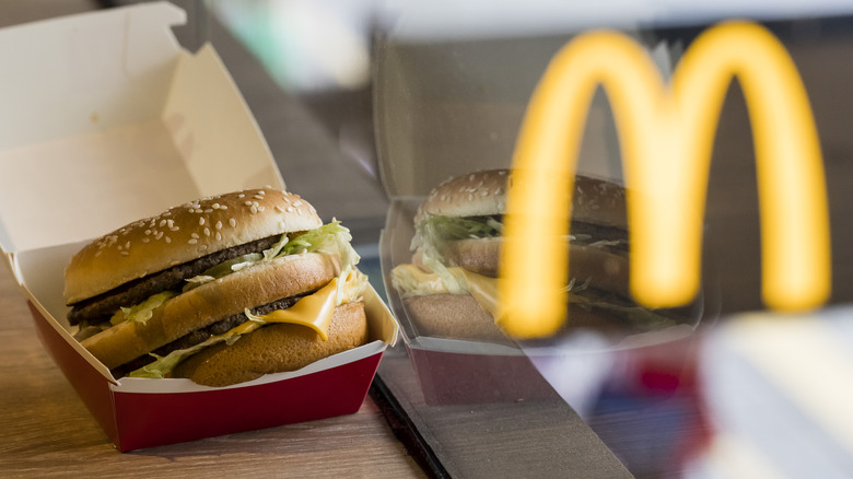McDonald's Big Mac next to window with "M" reflection