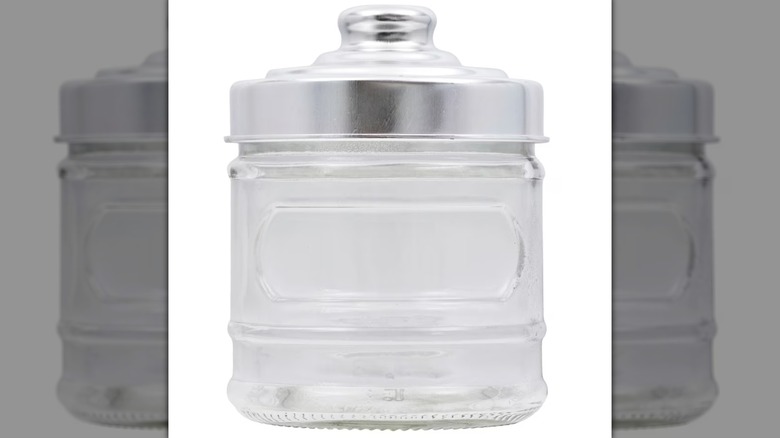 A rounded glass storage jar with silver colored lid