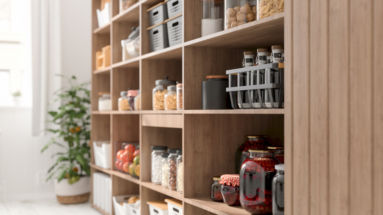 A well-organized pantry wall with light brown-colored wood shelves