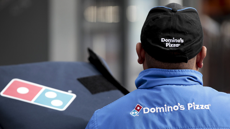 delivery driver carrying Dominos pizza box