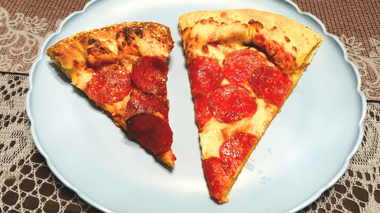 Two open boxes of pizza showing the size differences in a medium and large