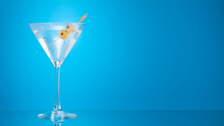 Martini with olives in opposition to blue background   GREEN TOMATO SOUP WITH ROASTED CHILLIES intro 1677716867