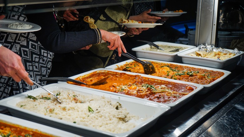 Customers serving themselves at an Indian food buffet