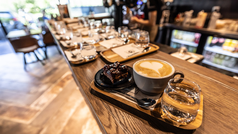 The interior of an Italian bar with a plate of coffee, cake, and water on the counter.
