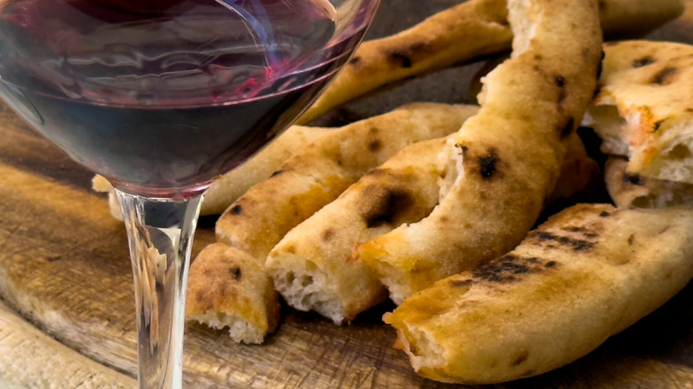 leftover pizza crust with glass of wine