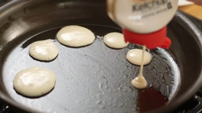 Squeezing pancake batter out of a ketchup bottle