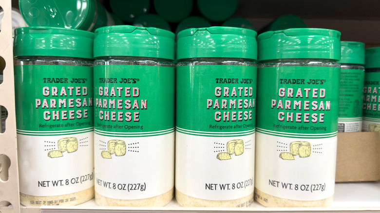 Bottles of Trader Joe's grated Parmesan cheese on a store shelf