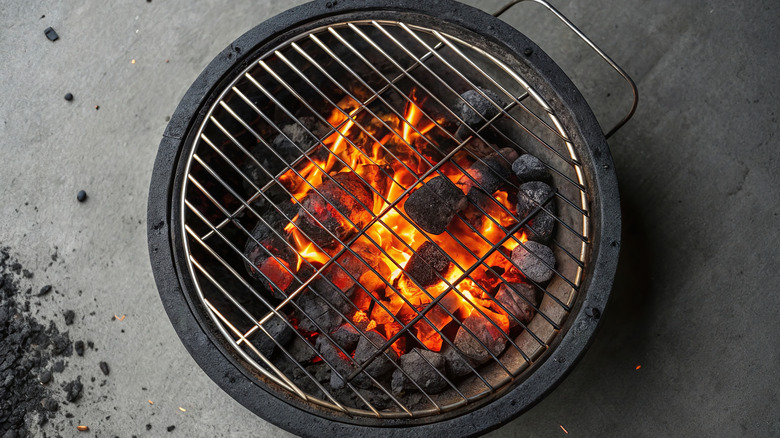 Lit charcoal grill on gray background
