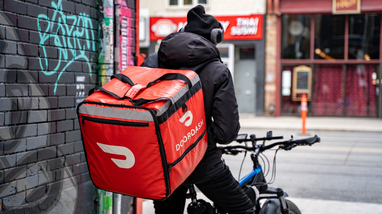 A DoorDash food delivery courier on an bicycle