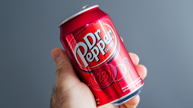 Hand holding can of Dr Pepper