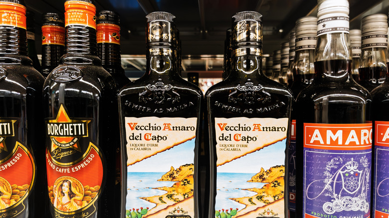Bottles of Amaro lined up on a shelf with labels outward