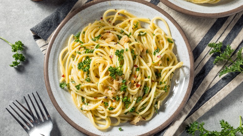 Butter noodles with herbs and pepper flakes on linens