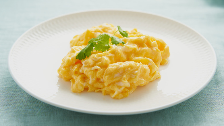 Plate of scrambled eggs garnished with parsley